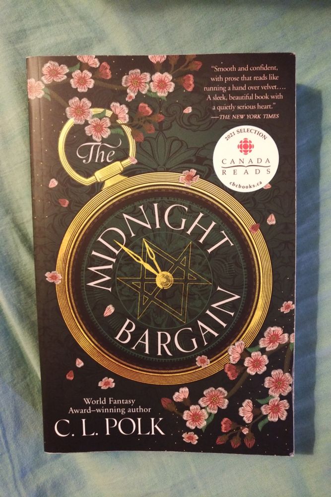 The Midnight Bargain by C L Polk

A gold pocket watch with a dark face and golden six-pointed star traced in fine linework. The watch is lying on the green ground with pink flowers scattered around.
A white CBC Canada Reads logo highlights the book as a selection for Canada Reads one year.