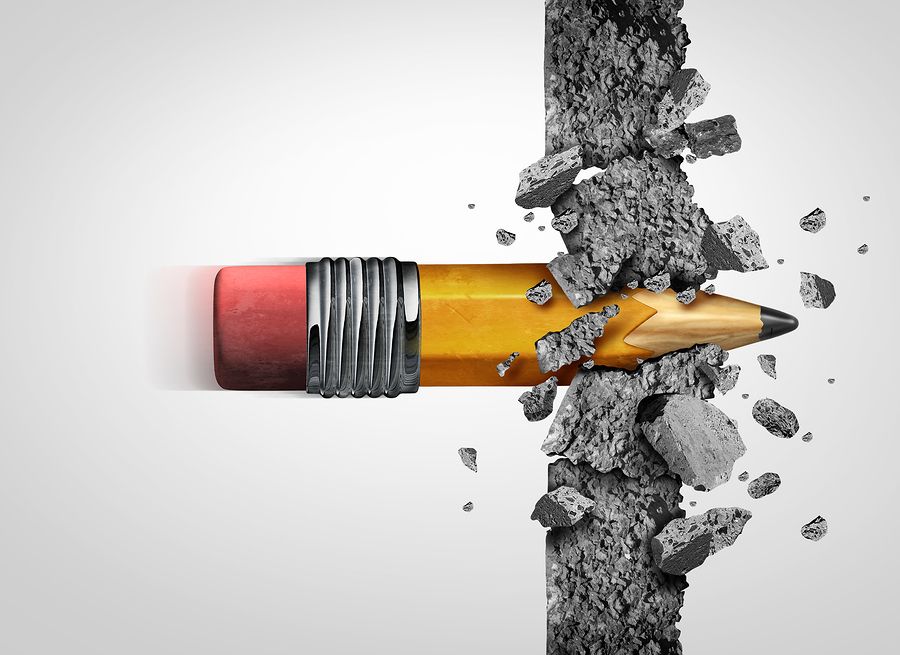 Sharpened pencil smashing through a concrete wall to represent the ability of words to break down barriers.