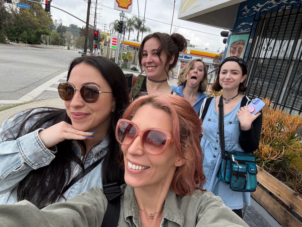 Group of 5 women smiling on the street 