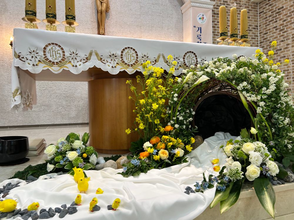 부활절 컨셉으로 꾸며진 예쁜 제단. 동굴 같은 모양에 흰첨이 나와있고 주변은 꽃들로 장식. 작은 병아리 장식들이 기어나오듯 배치되어있음
