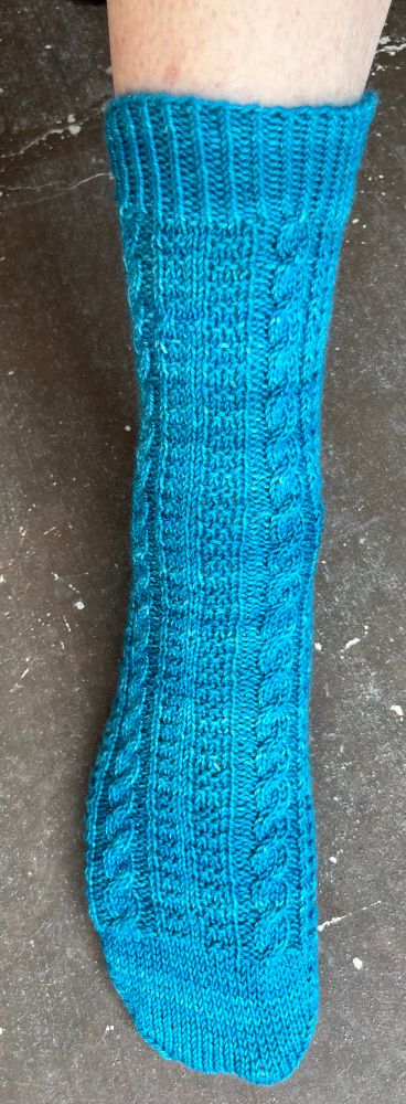 Sock front 2 cables with texture. Back 3x1 rib EOP heel. Yarn Madelinetosh Twist Light 