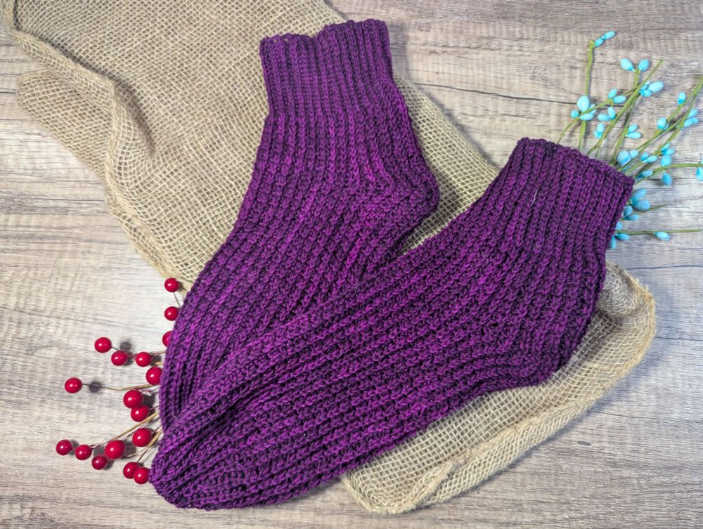 Crocheted socks that are purple and look similar to being knitted