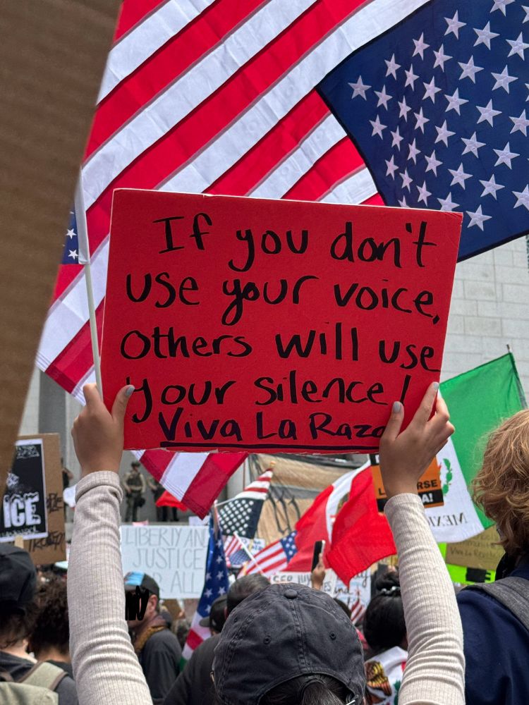 A protest sign that reads: “if you don’t use your voice, others will use your silence! Viva La Raza”