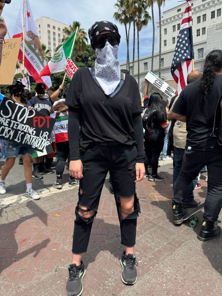 Marching at a protest, a sign that says “stop pretending ur racism is patriotism”