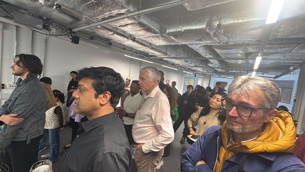 A room full of people listening to a speech at the opening night of an arts festival