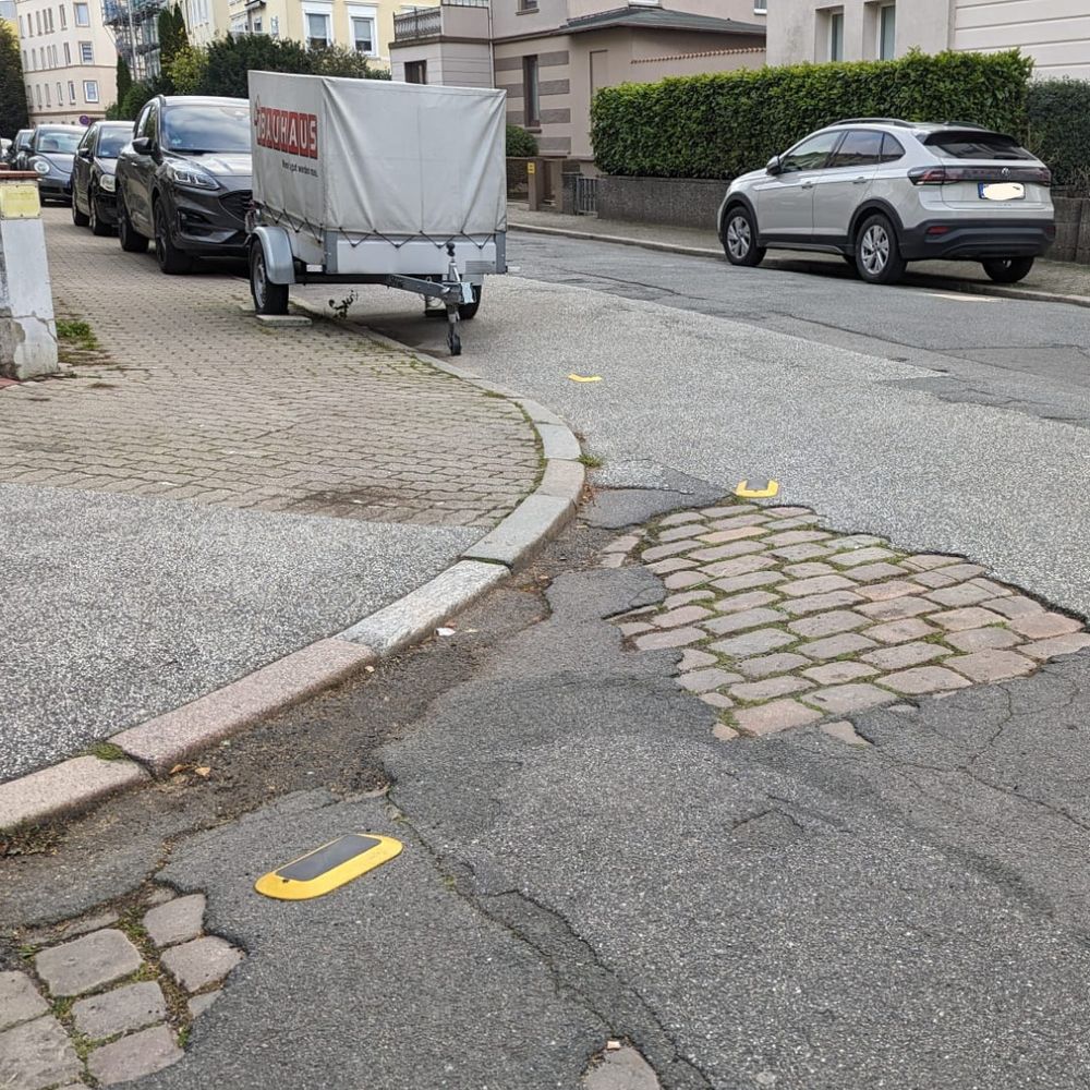 Eine Straßenkreuzung in Lübeck. Im Boden sind digitale Sensoren verbaut, die Falschparker*innen an das Ordnungsamt melden.