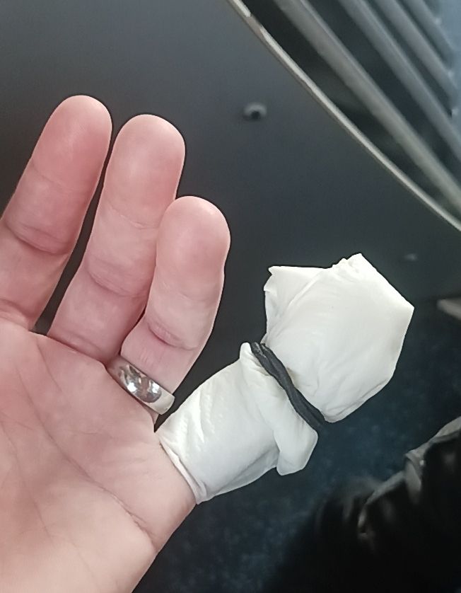 Photo de mon doigt enveloppé dans du sopalin imbibé d'eaux, tenu par un élastique à cheveux