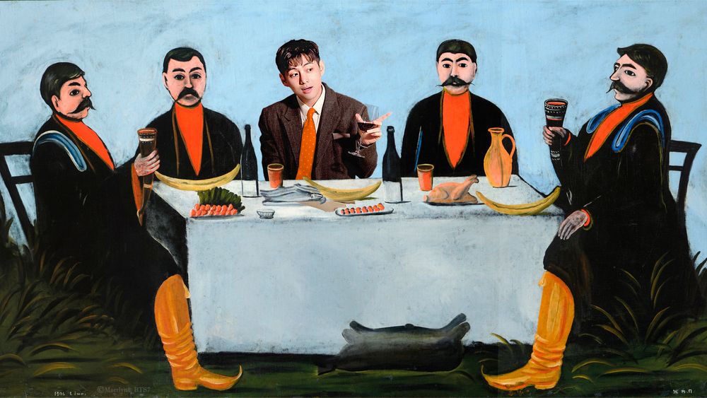 Taehyung at a table with four other (very serious looking) men, holding up a glass of wine as he points and smiles.