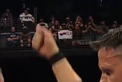 Blurry sign in the background of AEW Collion that actually says "Listen To Waffly Bollox"
