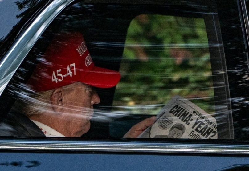 AP photo of Donald Trump riding in the back of his limo reading a page in some kind of newspaper showing Chinese president Xi Jinping with comments that appear to be tariff related.