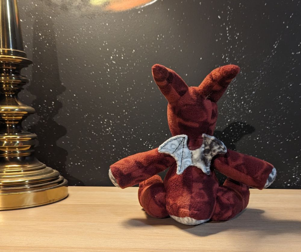 a back view of an 8 inch burgundy and white floral themed plush dragon