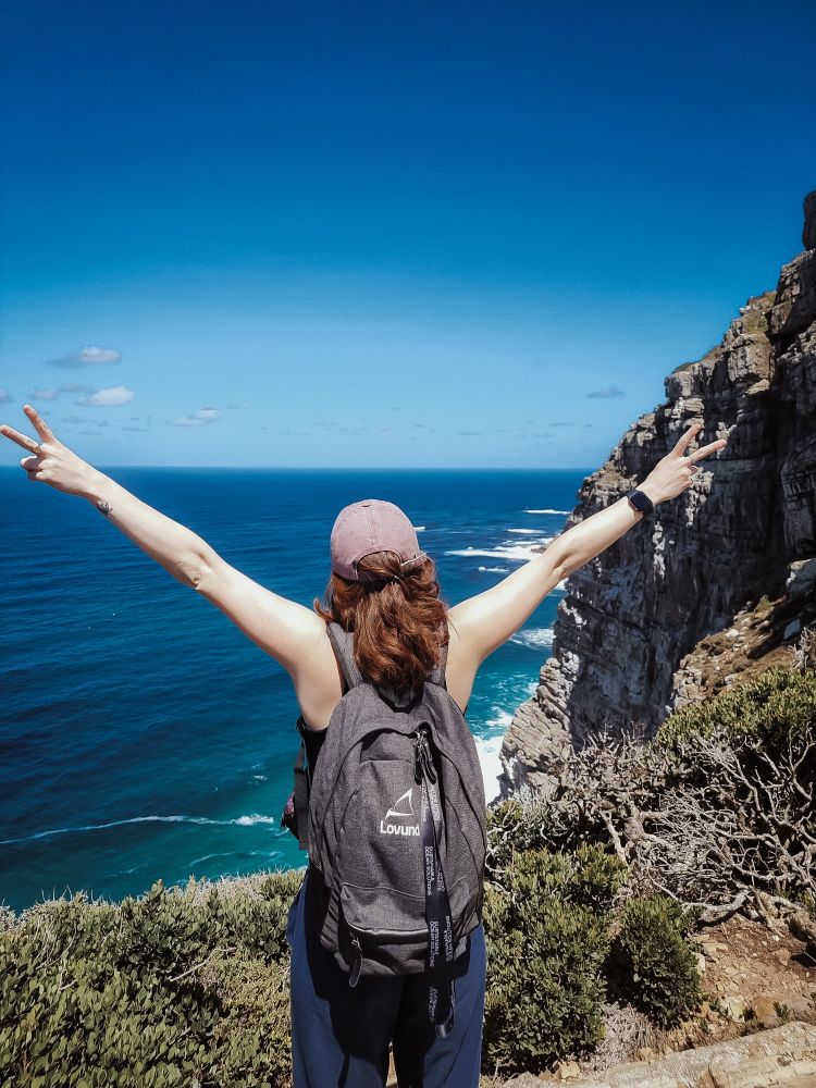 Woman facing ocean scape. Circa Feb 2024, Cape Point, South Africa.