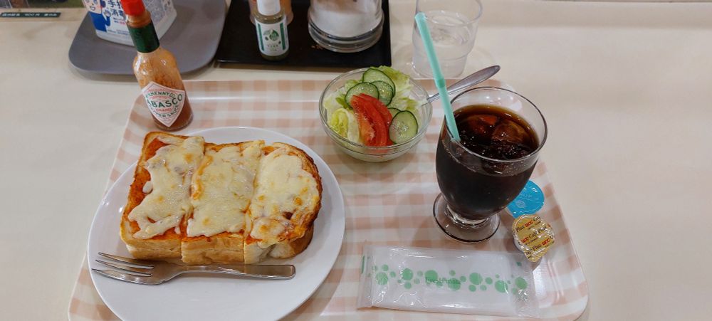 Cheese toast, salad and an iced coffee on a tray 