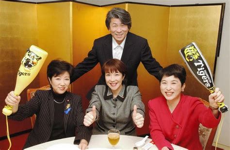 阪神タイガースのメガホンを持つ小池都知事、高市氏、社民党代表の福島氏が並んで写ってる写真。後ろに男性もいるけどどなたかわからない…