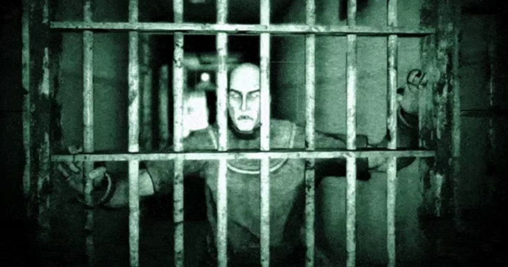 a man is behind bars in a dark room