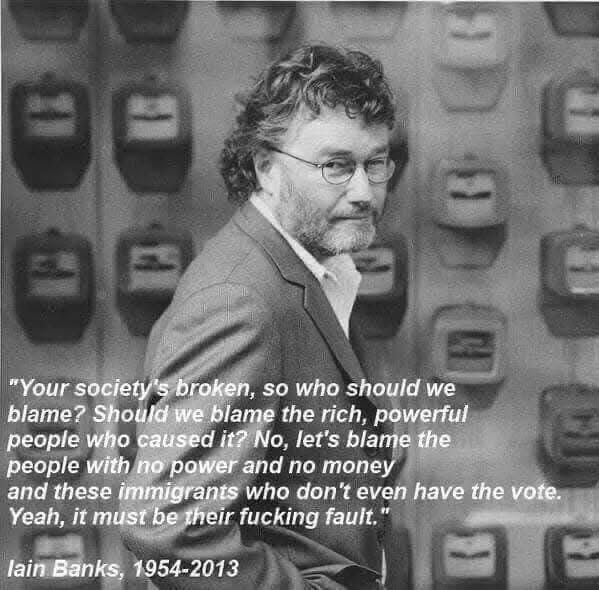 Photo of a bearded man in a suit jacket and white shirt with a quote: “your society’s broken, so who should we blame? Should we blame the rich powerful people who caused it? No. Let’s blame the people with no money and no power and these immigrants who don’t even have the vote. Yeah, it must be their fucking fault.”Iain Banks 1954-2013