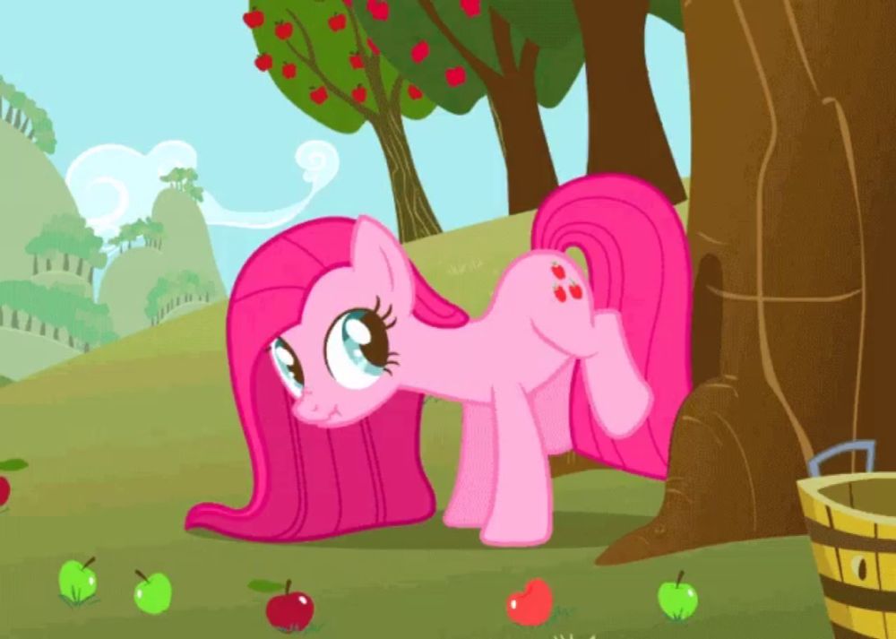 a pink pony is standing next to a tree with apples around her