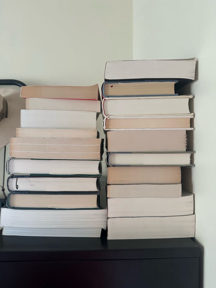 Photo of the 20 books destined for the used book store. I am intentionally only showing the bottoms of the books because I don't want anybody to see their book in that pile and have a bad feeling, so please no one ask for the titles of the books.