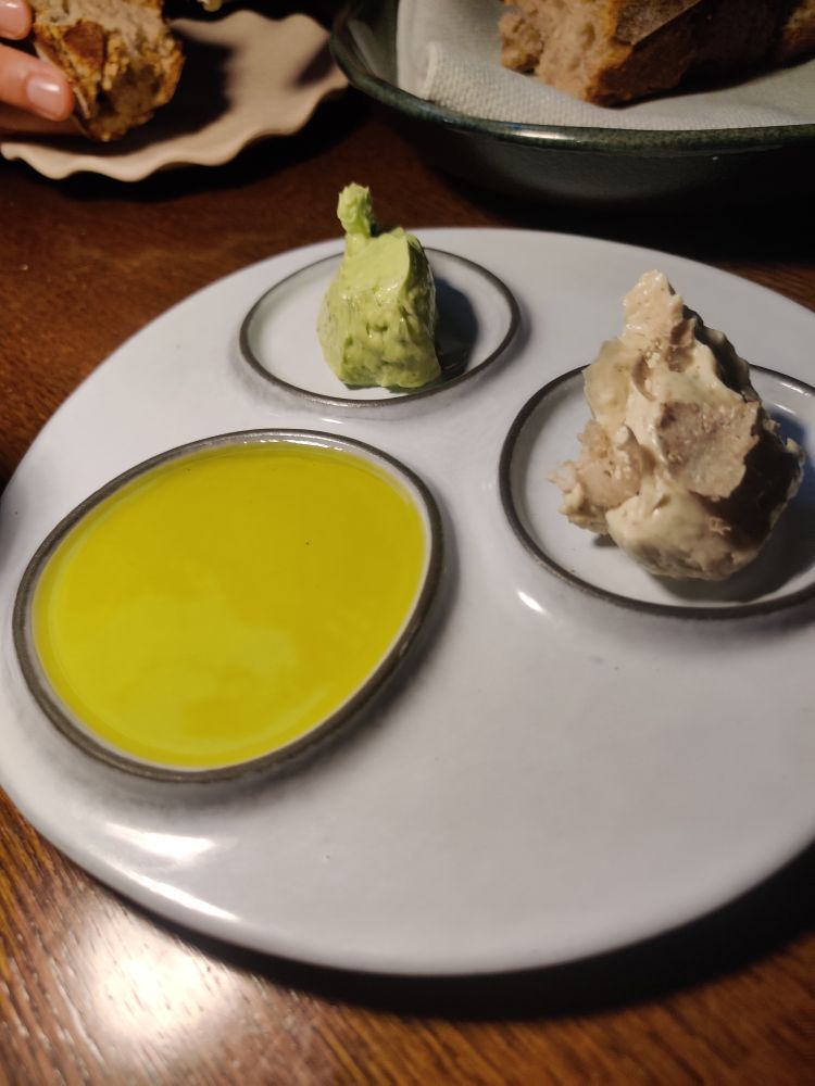 Three small round plates. One contains olive oil, one has truffle butter and the other basil butter. All three tasted amazing 