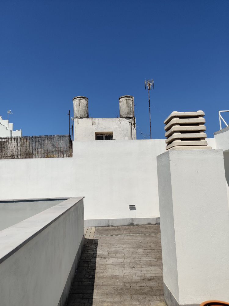 The white walls of the hotel roof and chimney-like ventilation outlet 