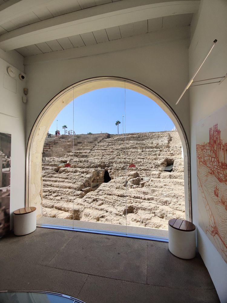 A view of the terraced seating through an arched window in the visitors centre