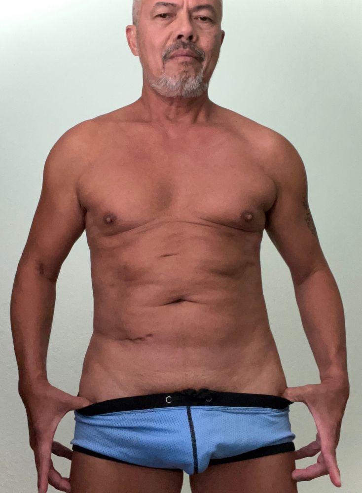 Pious Ramon is wearing a tiny blue bathing suit. 