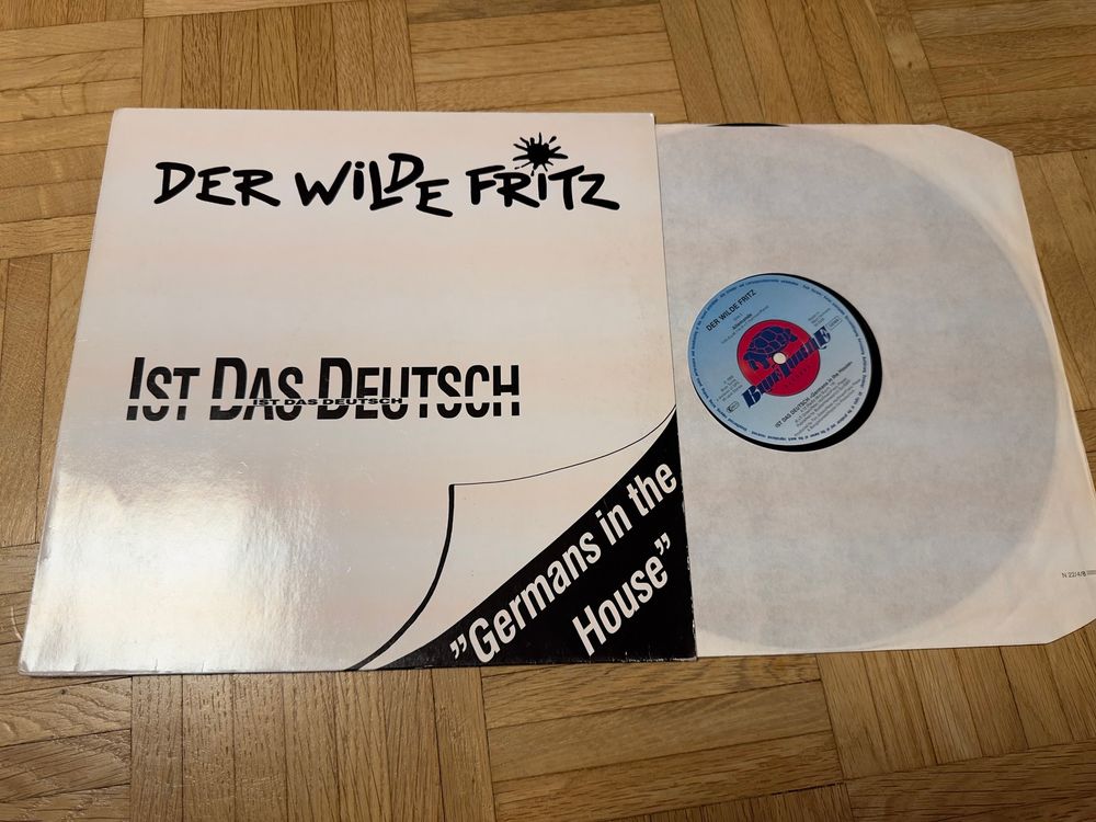 Zeigt die Schallplatte „Der Wilde Fritz - Ist das Deutsch“.
Schwarz-Weißes Design. Mit dem Untertitle „Germans in the House“