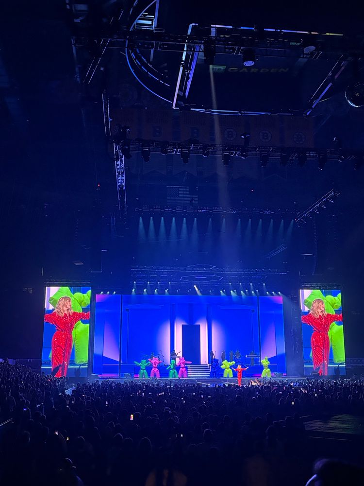 Kylie onstage singing in front of dancers in blow up inflatable costumes. 