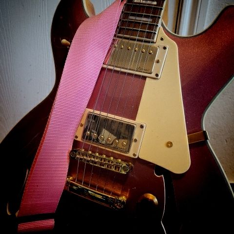 A pink semi-hollow guitar