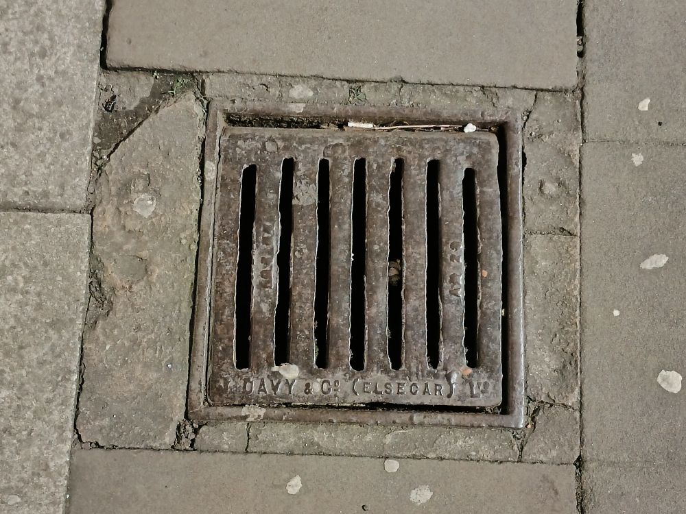 Square cast iron drain grate with the words J Davy and Co. (Elsecar) Ltd along the bottom of the frame. 