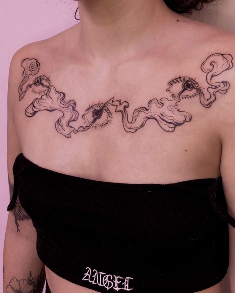 Tatuagem no peito de olhos com fumaça saindo das respectivas íris
