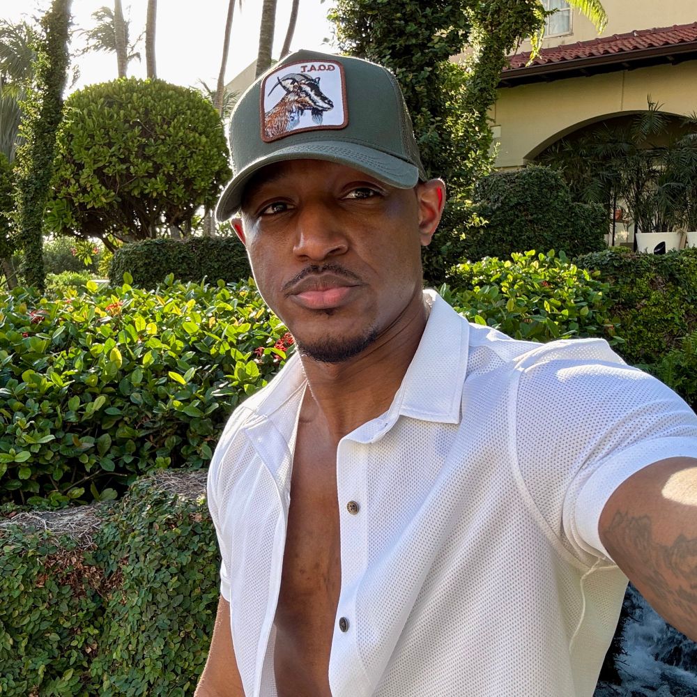 Antoine (Designer Baddie), 36 and fine as fuck standing in front of some greenery 