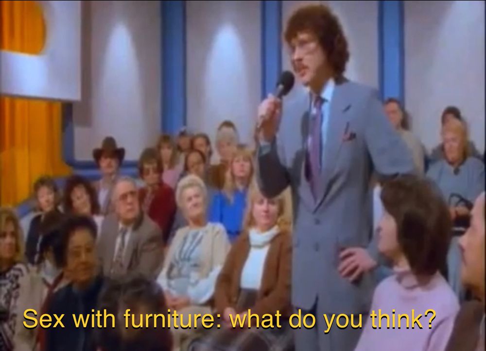 Screenshot from the movie UHF in which Weird Al asks a talk show audience “Sex with furniture: what do you think?”