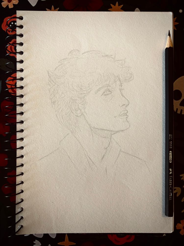 A pencil sketch taken from my sketchbook. A young man smiles slightly, looking upward toward another person out of frame. They appear to be sharing a happy memory or story.