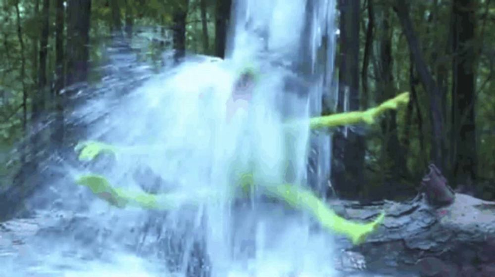 a person is laying in a waterfall in the woods