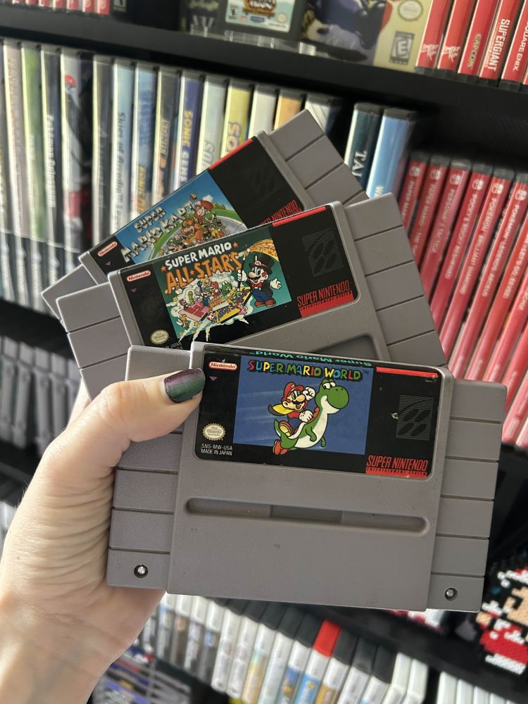 a picture of copies of super mario kart, super mario all-stars, and super mario world for the super nintendo