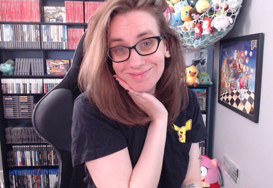 a picture of megan in her stream room. she is wearing a black tshirt with a pikachu peeking out of a pocket.