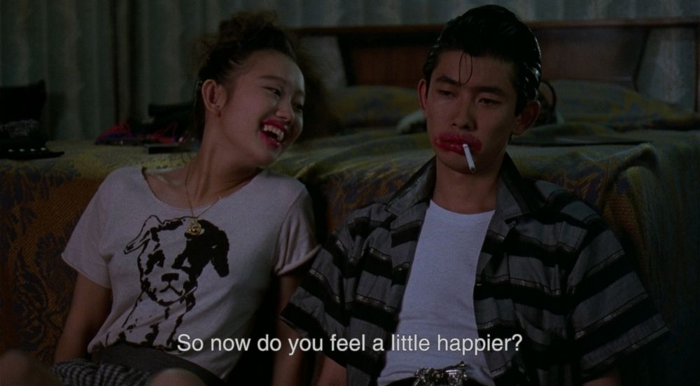Mystery Train
Youki Kudoh addresses Masatoshi Nagase, they both have lipstick smeared around their mouths. Caption reads "So now do you feel a little happier?"