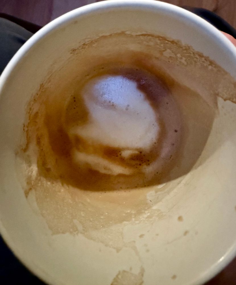 A blob monster with a cute little smile is staring back at me from the foam of the coffee cup.