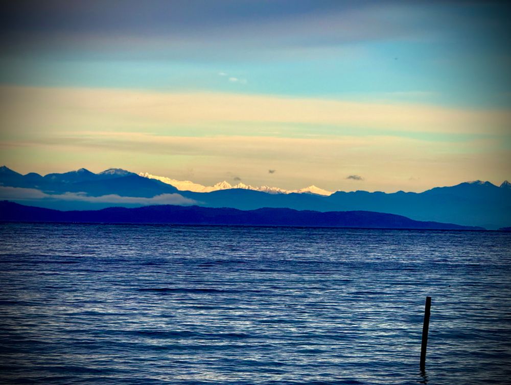 Layers of blue of the sea the islands and mainland mountains. Climbing higher, they glow white in the distance with fresh snow.
