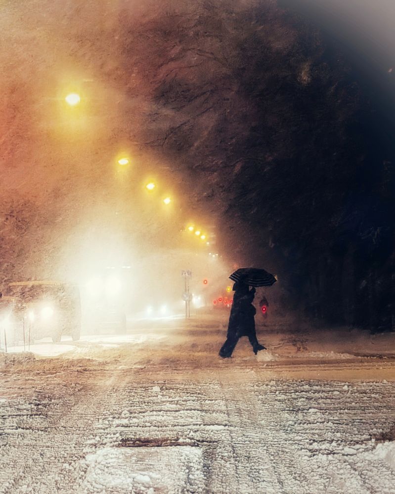 Person crossing the street during snow storm.