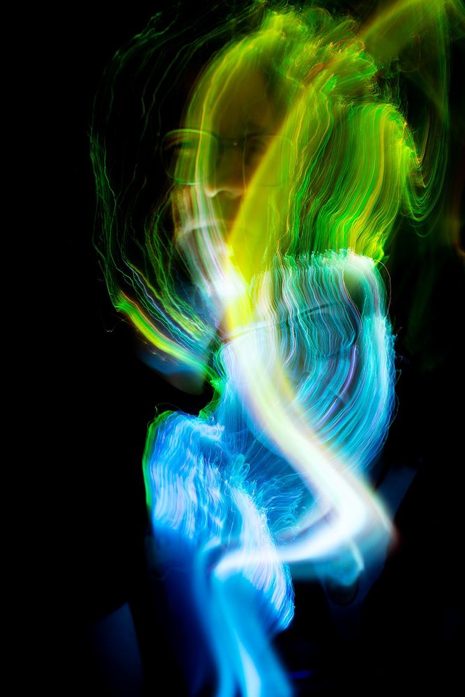 Trippy spirit photography taken by photographer Julie K Gray from Maine. Colorful auras wiggle and float around her subjects giving a psychedelic glow in the darkness. 