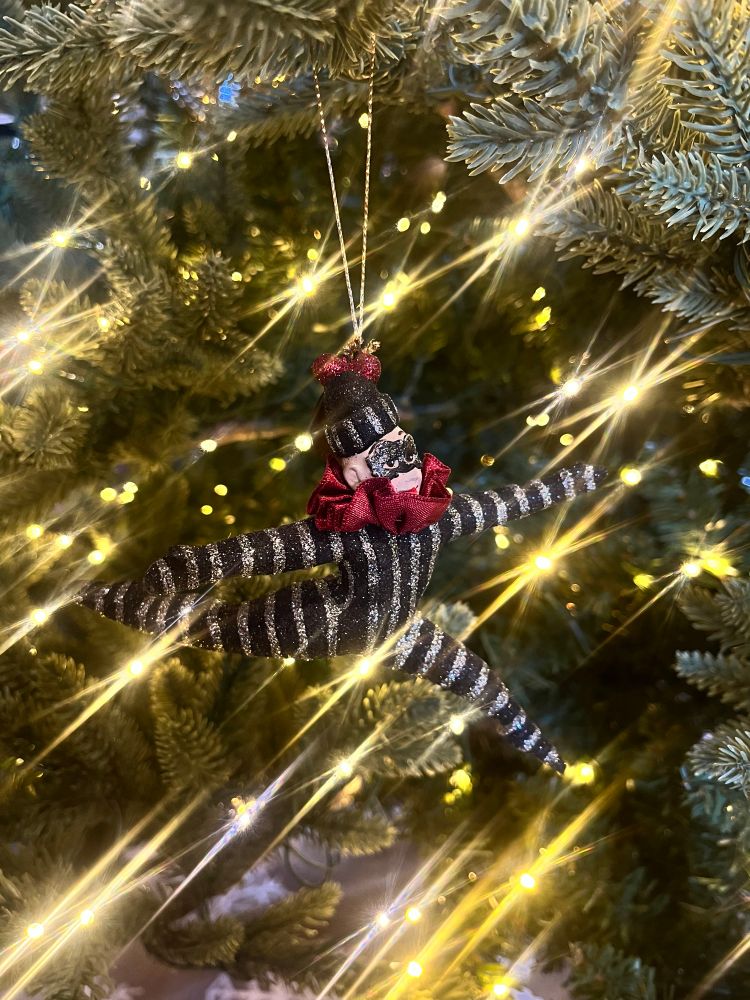 Terrible picture of an ornament of a guy in a black and silver striped costume leaping through the air