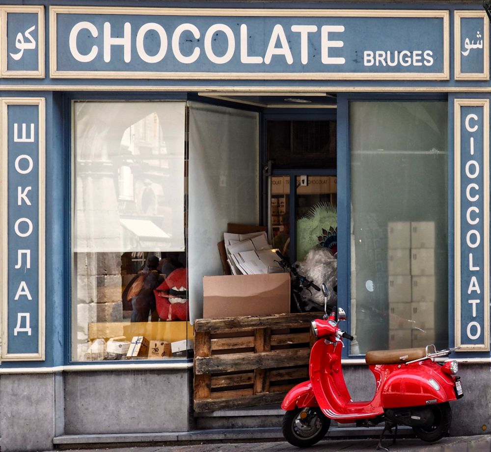 Chocolate shop in Brügge with a red Vespa in front of it