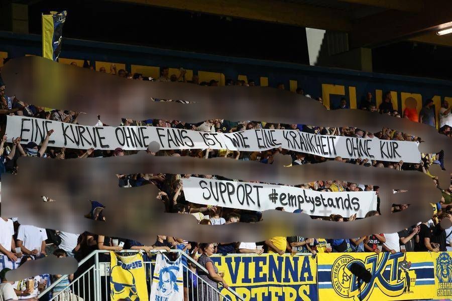 Die Kurve von First Vienna aus Wien mit der Tapete: "Eine Kurve ohne Fans ist wie eine Krankheit ohne Kur - support #emptystands"
