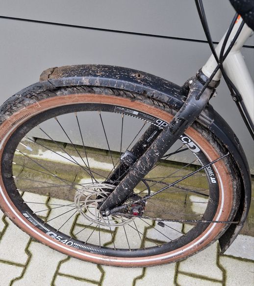 Ein dreckiges Vorderrad eines Fahrrads