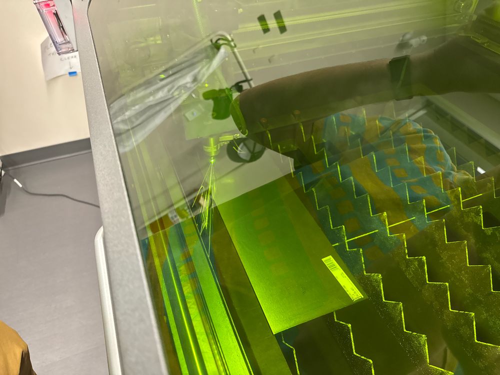 A metal laser cutter cutting some steel with large sparks flying out