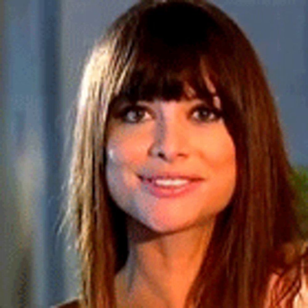 a close up of a woman 's face with long hair and a fringe .