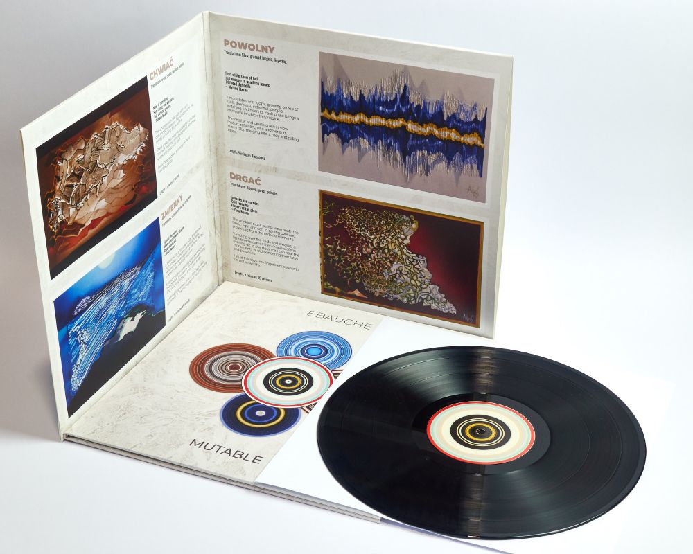 Photo of Ebauche - Mutable gatefold vinyl sleeve open, with another copy lying on its back showing the front cover, on top of which lies the record outside the sleeve.