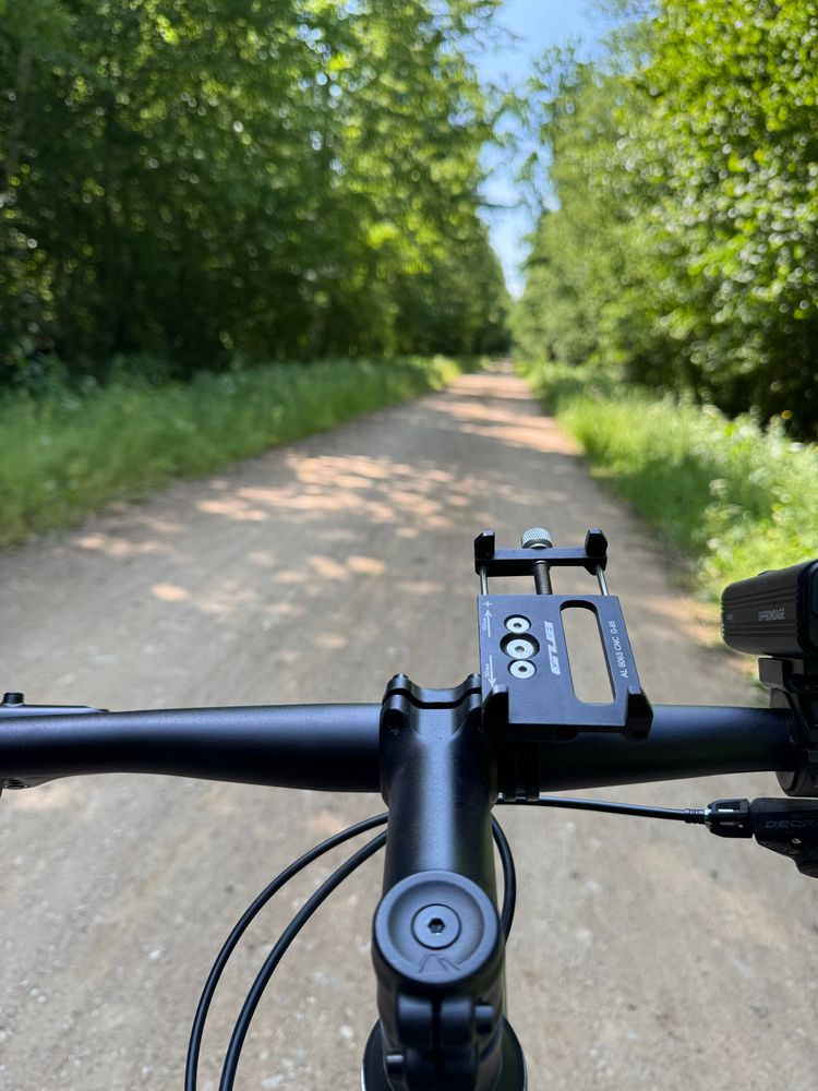 Bike in foreground and gravel path in the woods in background 